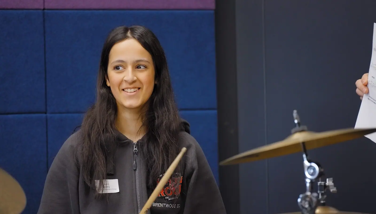 Student playing drums for video production